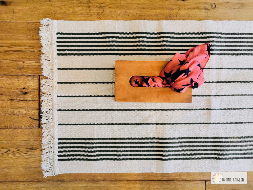 Greifübung mit einer Taschentücherbox - eine von vielen kostenlosen Spielübungen für euer Baby