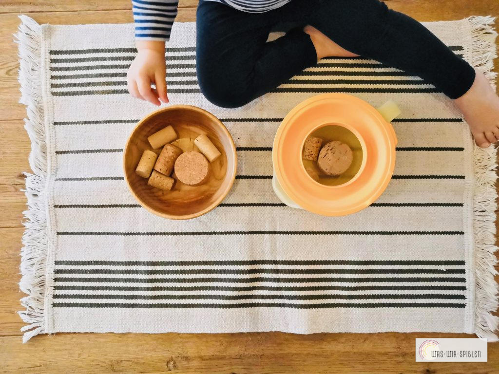 Füllübung mit Korken und einem Messbecher - ideal für Babys und Kleinkinder