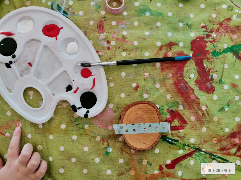 Als Erstes klebt man die Mitte der Holzscheibe mit Washitape ab