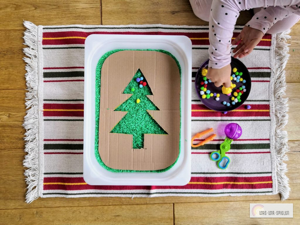 Mit bunten Pompons wird der Baum geschmückt