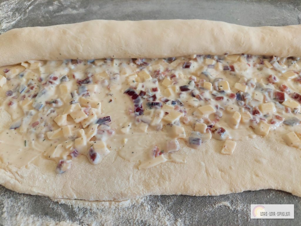 Teig mit Belag bespreichen