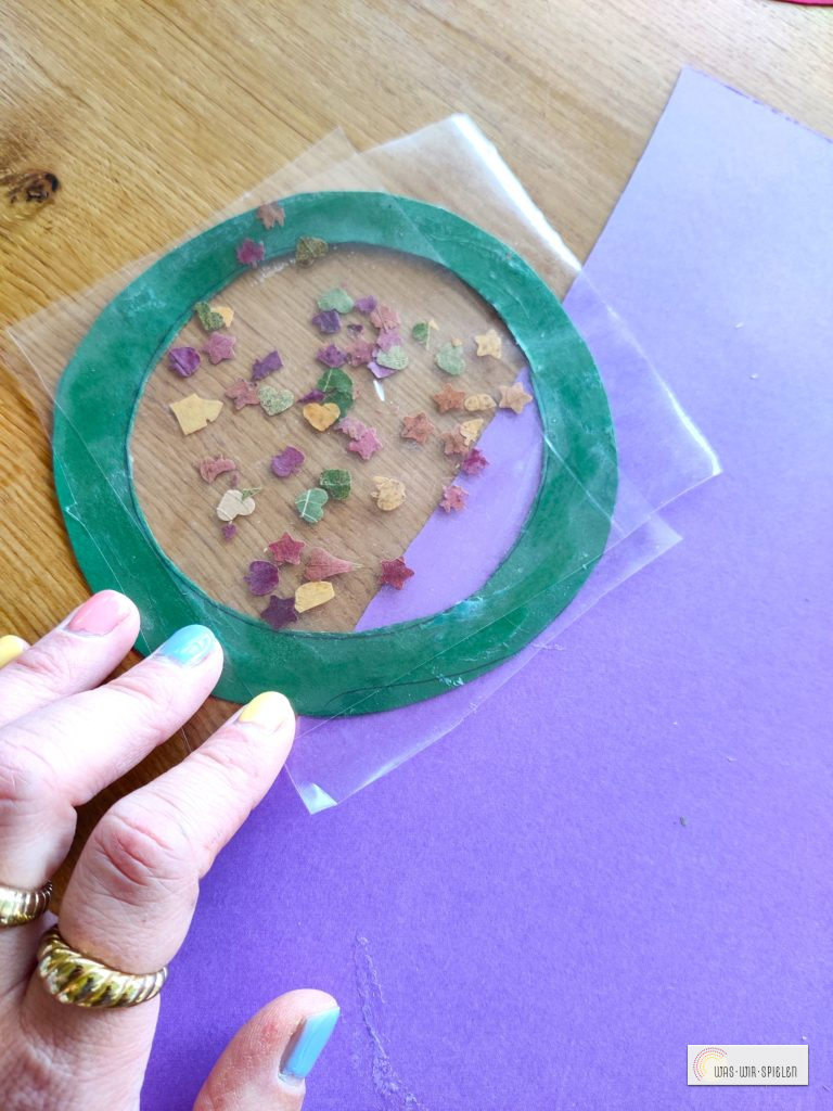 Blätterkonfetti aufkleben und mit zweiter Folie abdecken