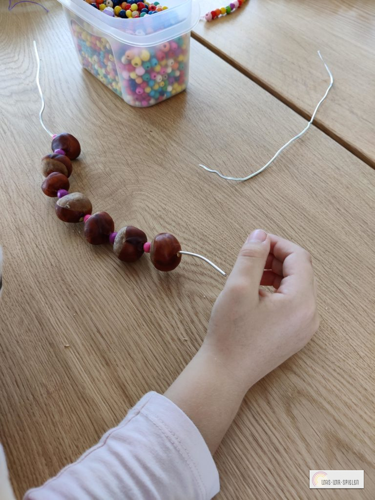 Kastanien und Perlen auffädeln