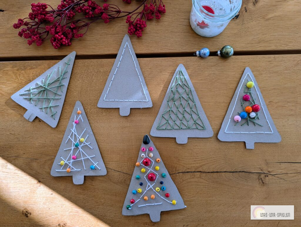 Selbstgemachte Tannenbaum-Anhänger aus Karton mit Wollmustern