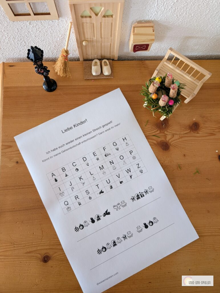 Arbeitsblatt mit weihnachtlichem Wichtelcode und verschlüsselter Botschaft auf einem Holztisch